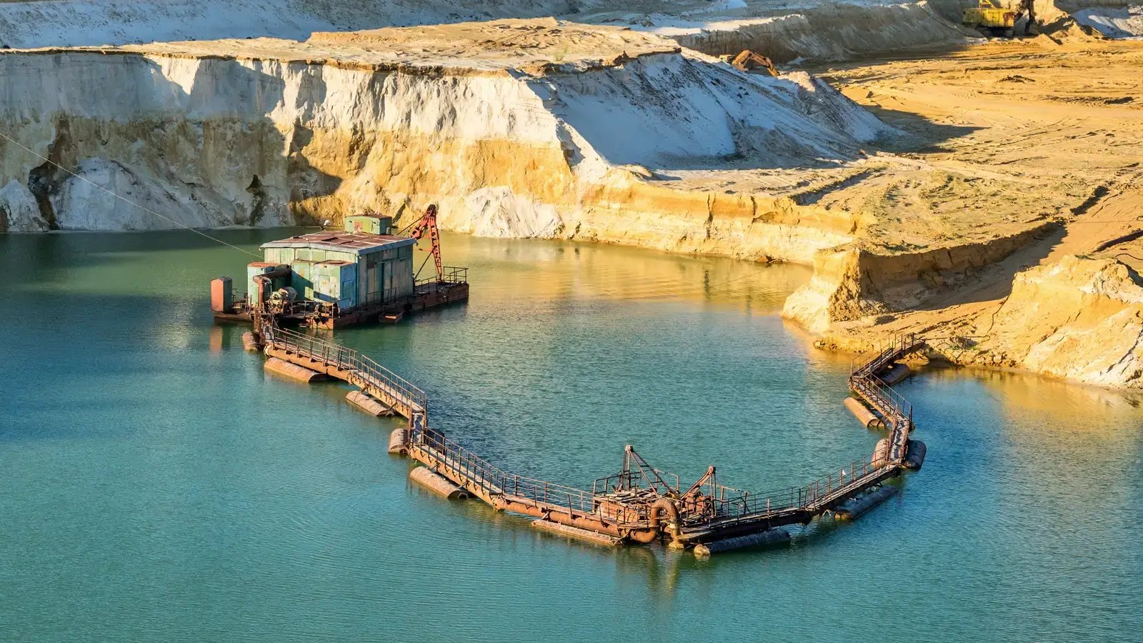 Conventional excavation equipment working in mining pond showing limitations of land-based sediment removal methods