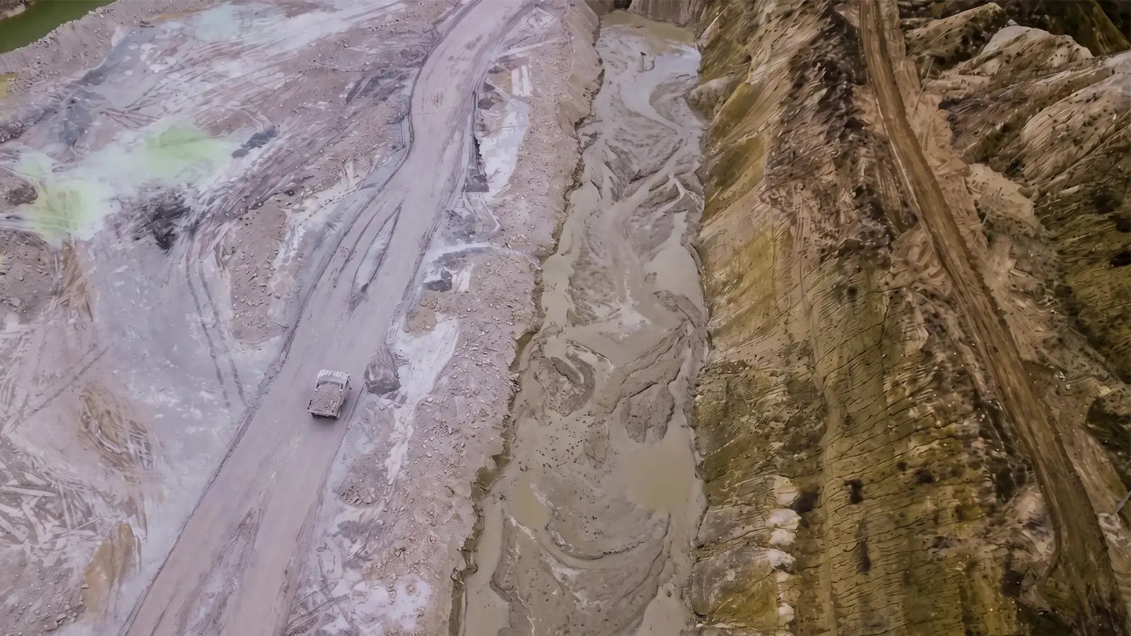 Aerial view of canal sediment buildup affecting mine operations with heavy equipment, showing sediment management, dredging conditions, and efficient material removal for mining projects in the USA.
