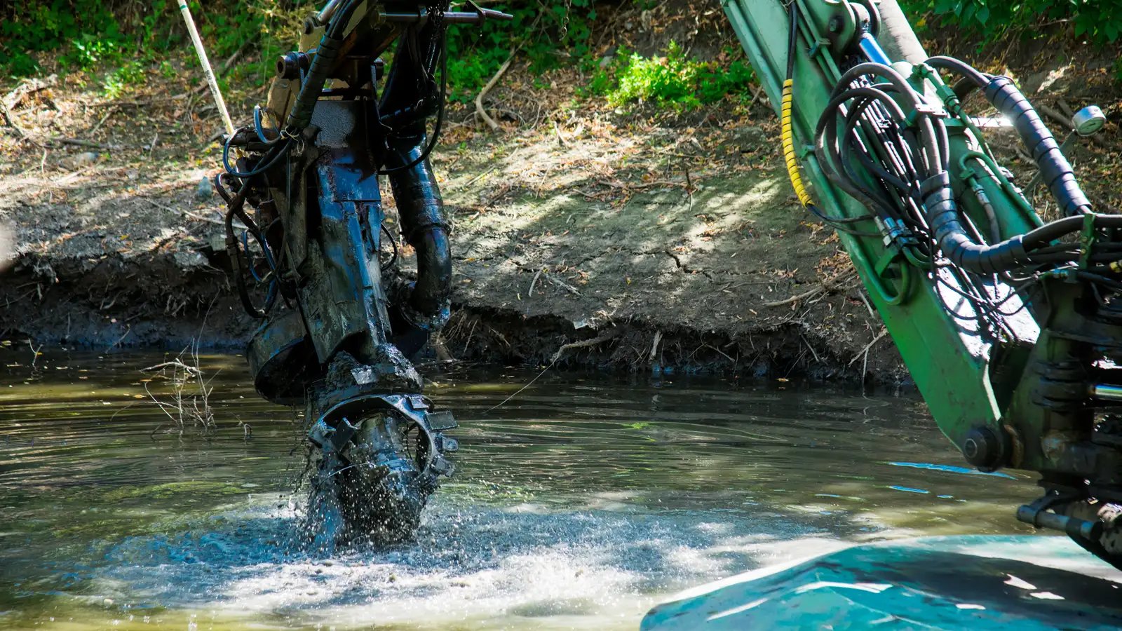 Excavator working in a mining canal with slurry hose during demanding dredging conditions where reliable pumping performance is critical.